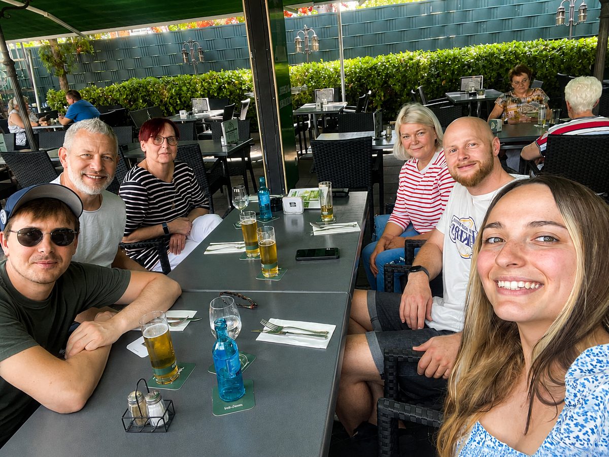 Das Team der Praxis sitzt gemeinsam an einem langen Tisch im Biergarten